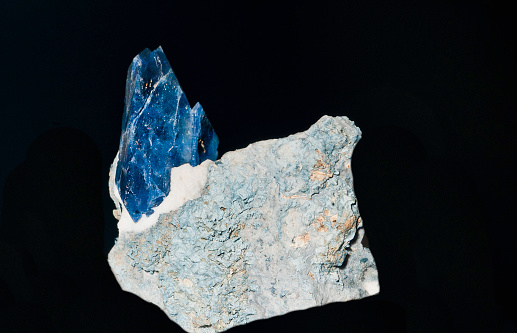 Blue Benitoite gem that still connected to the rock