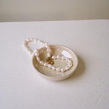 Rachel Saunders Ceramics Opalescent Catch All with a pearl necklace on it