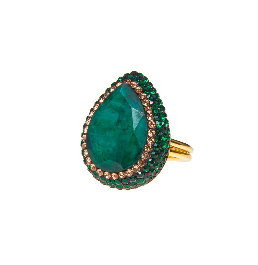 The green emerald ring is in the shape of an teardrop and is surrounded by mini gold beads on a white background
