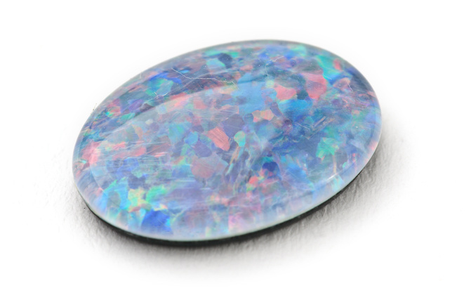 Opal gem with different colors inside on a white background
