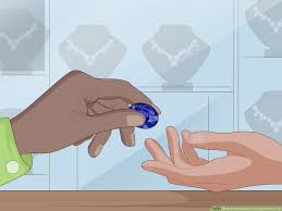 A customer in a jewelry store is handing the stone to the owner so that he or she can look at it