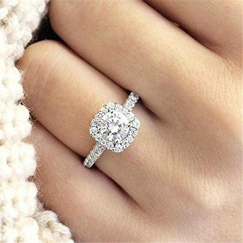 A square cut diamind ring on a lady's finger resting on some wool