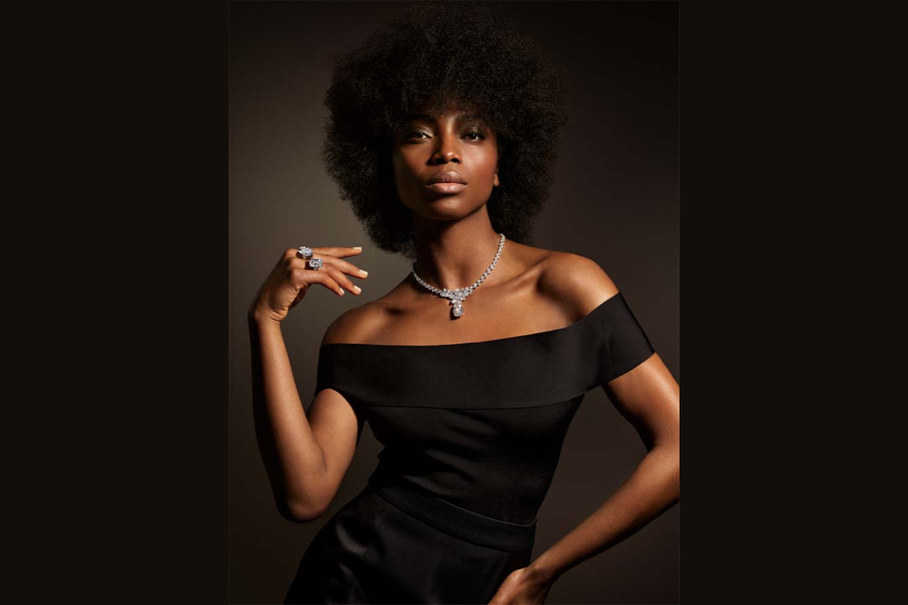 A stunning black woman wearing 13.69-carat flawless D color diamond necklace while posing