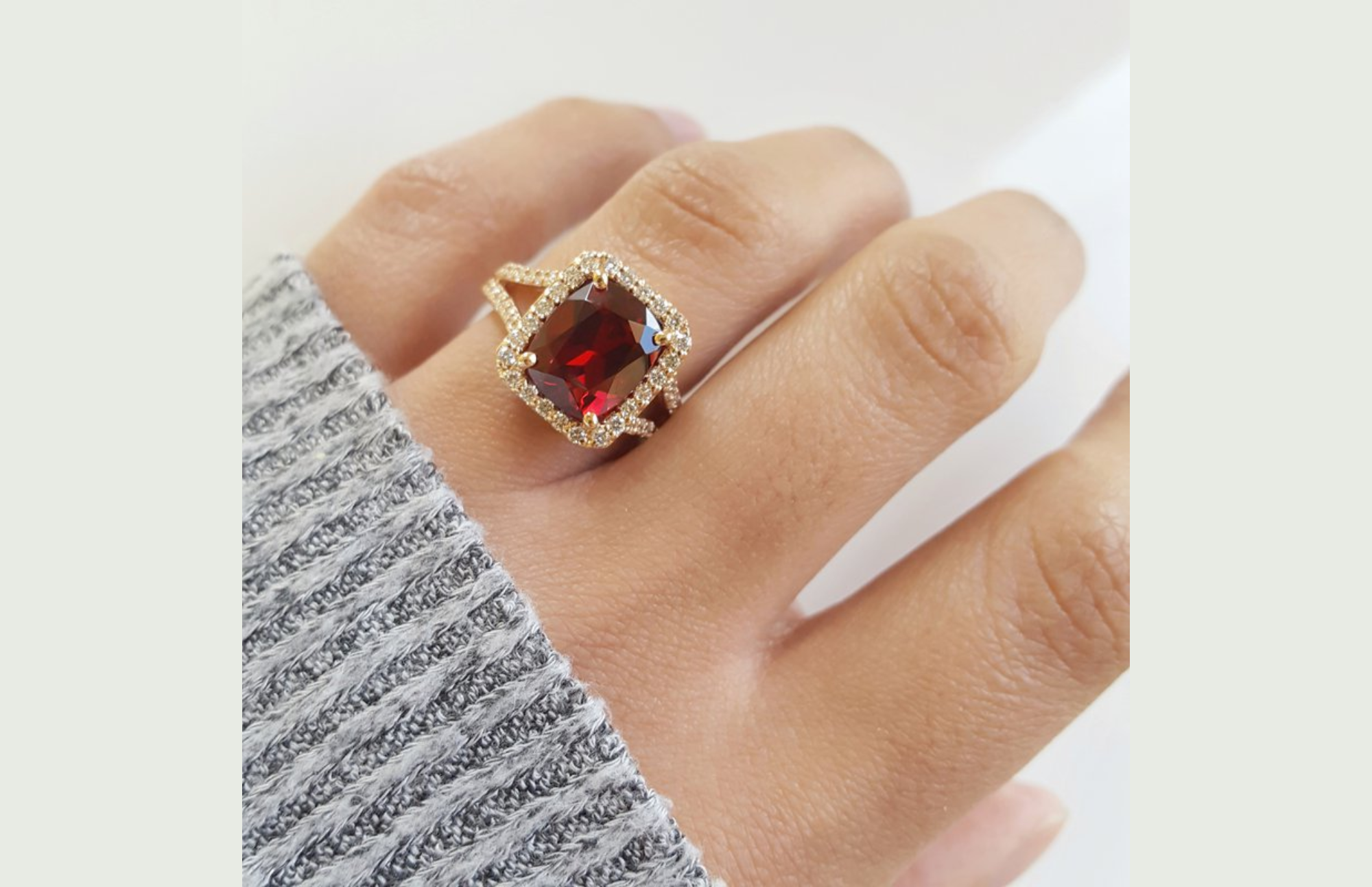 14k rose gold with a real garnet in an extended cushion shape measuring 4.90 carats on a woman's ring finger