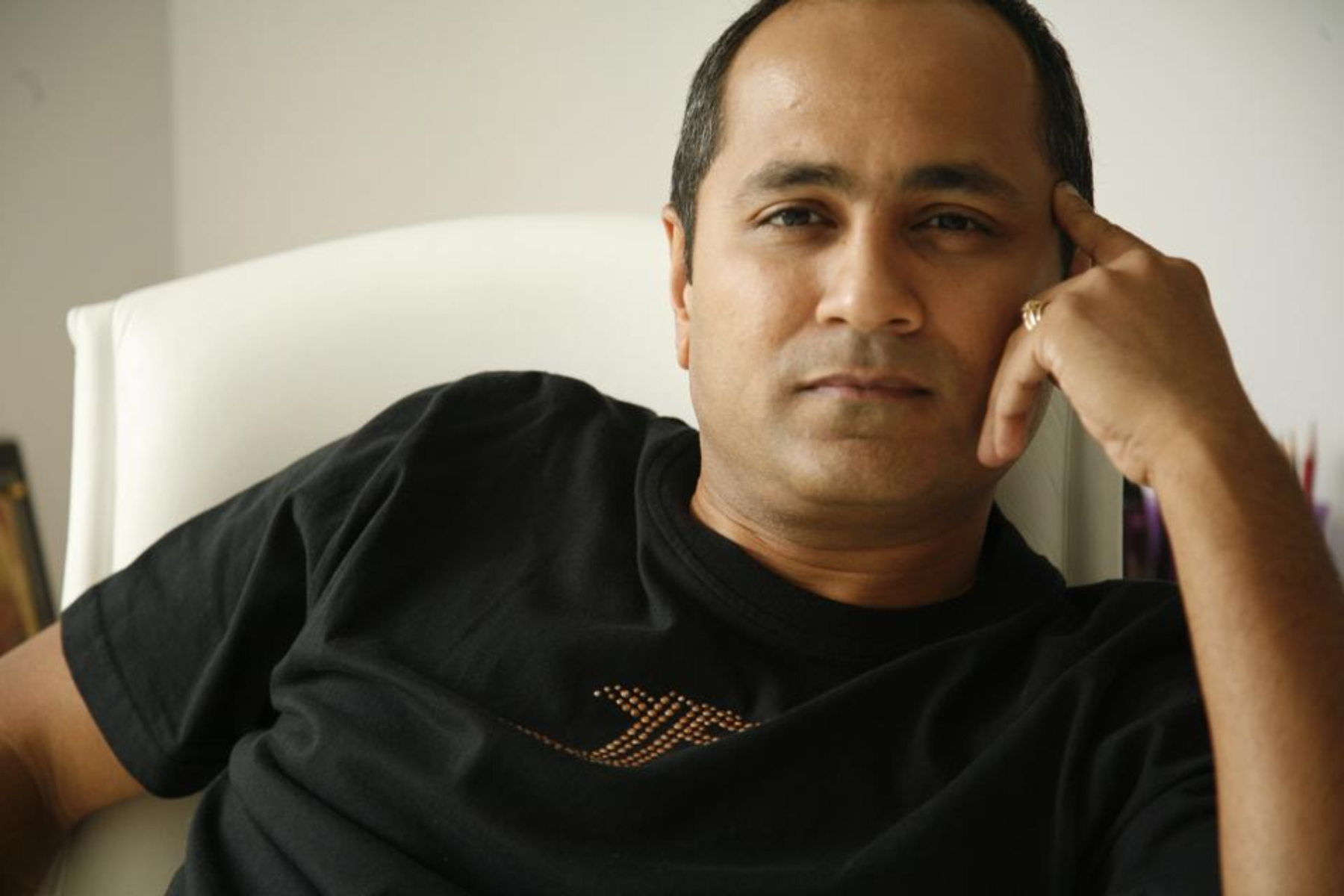 Vipul Shah is pointing to his head with his finger
