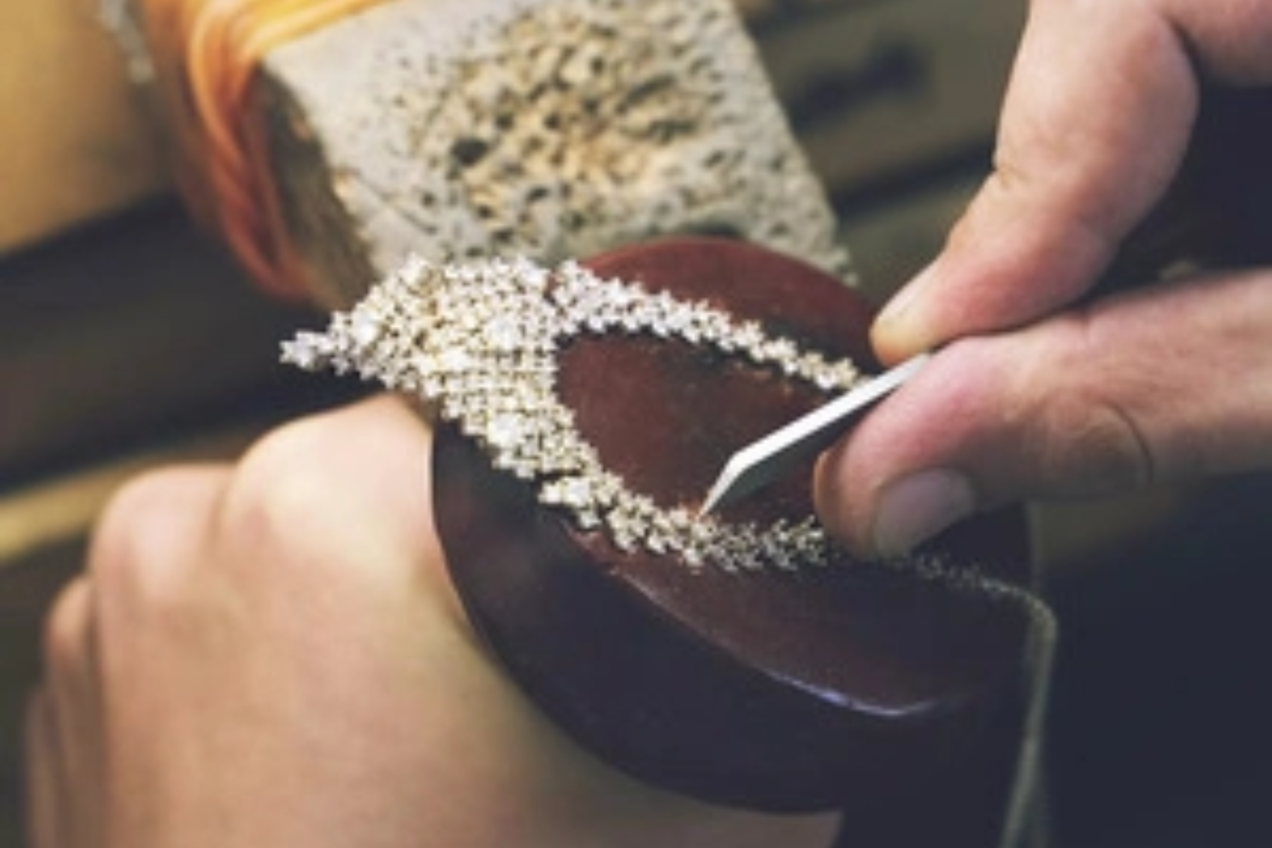 A man's hand carves a diamond on a circular type of hood
