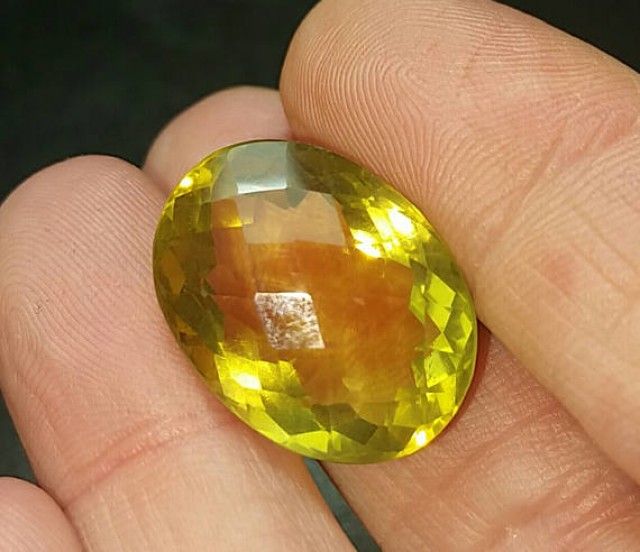On a hand, an ideal oblong citrine gemstone that resembles a lemon