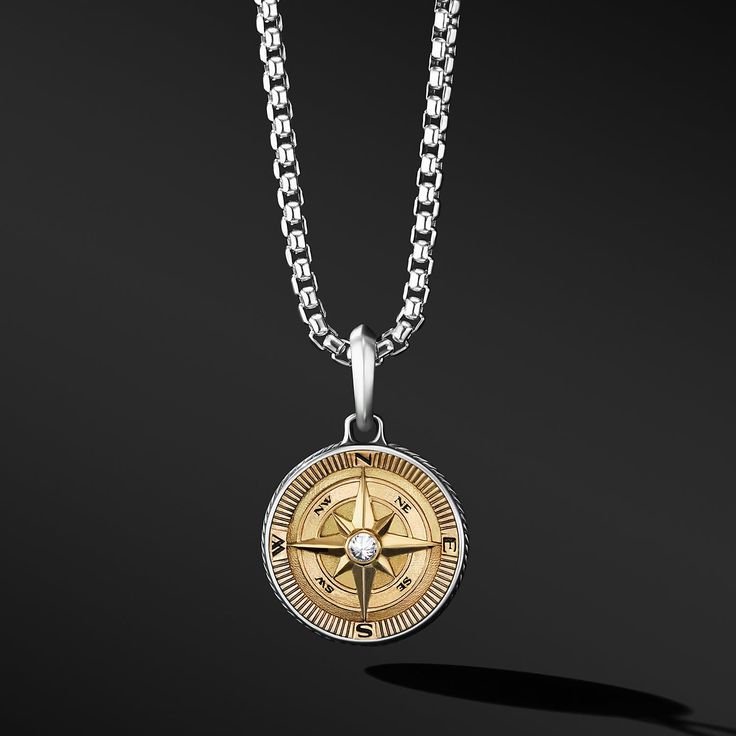 The pendant with a maritime compass amulet is hanging against a black background