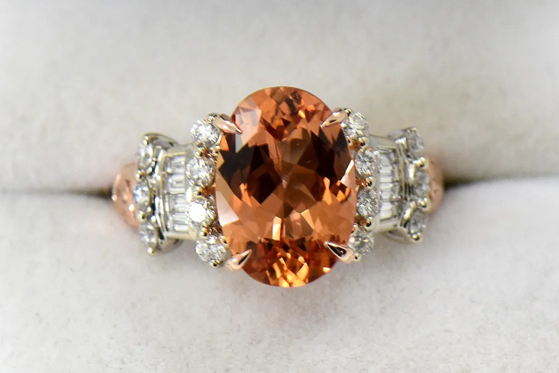 An oblong topaz stone on a sterling silver and diamond ring
