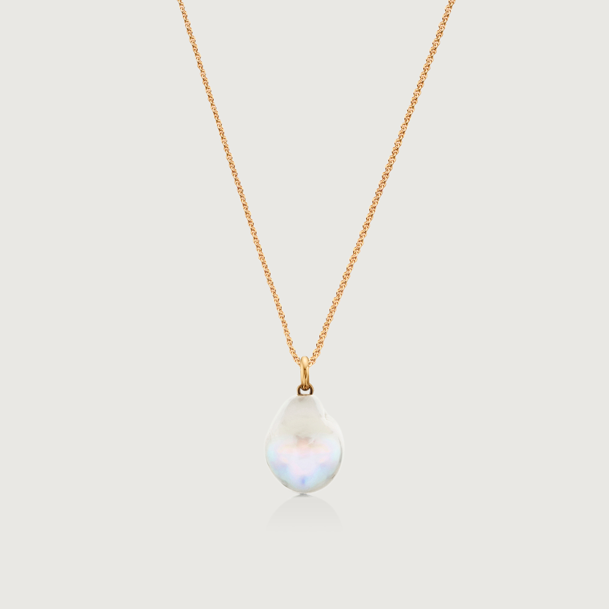 A gold chain with a flat pearl