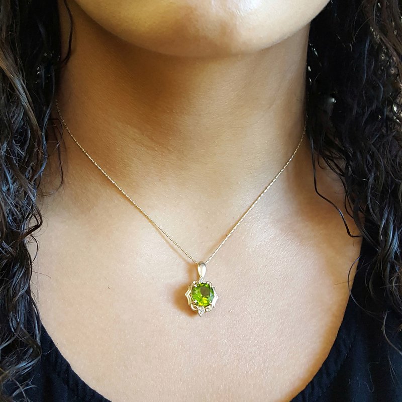 A woman wearing a necklace with a Peridot pendant