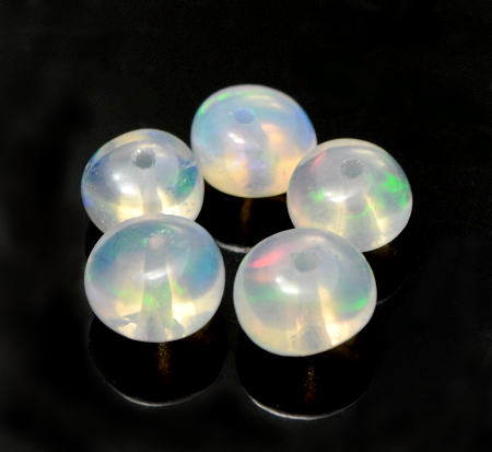 Five small round white opal stones