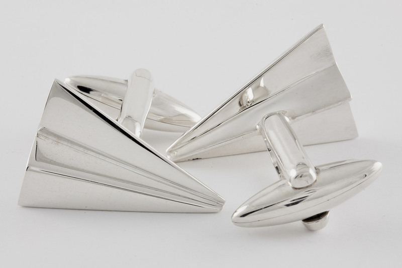 Two pieces of Silver colored Paper Aeroplane Cufflinks facing toward each other