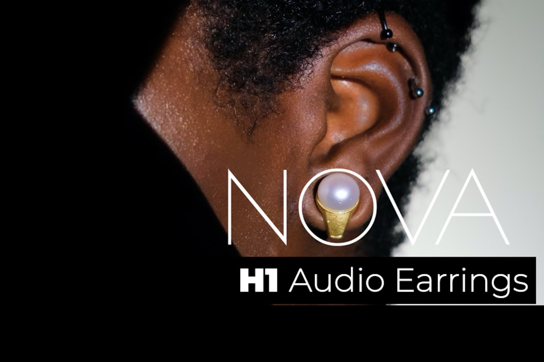 The Nova H1 wireless audio earrings on a black woman model