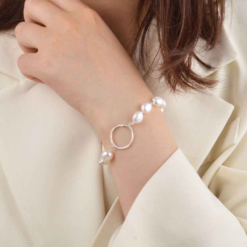 A woman wearing a silver bracelet with pearl