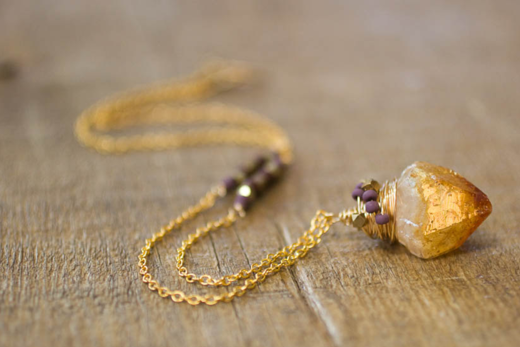 Citrine crystal pendant hanging from gold lace