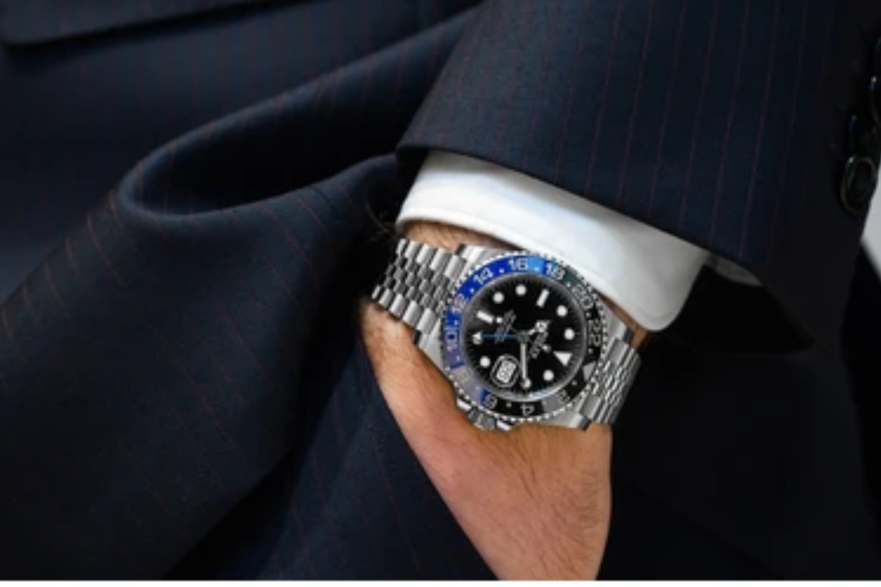 A wealthy man's wrist is decorated with a Rolex watch