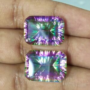 Two natural Brazil Mystic Topaz octagon loose gemstones on top of hand