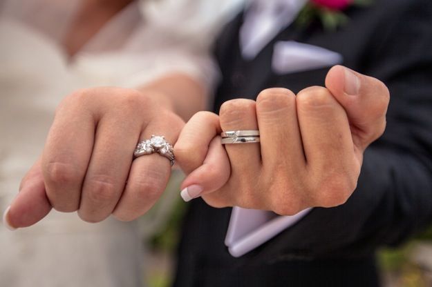 Husband and wife showing off their silver wedding rings
