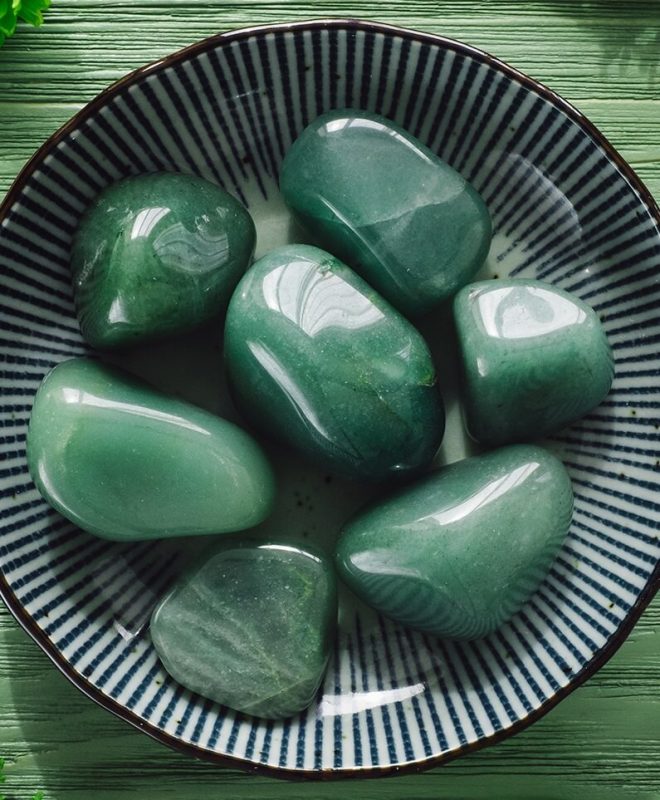 A dark green aventurine gemstone in a bowl