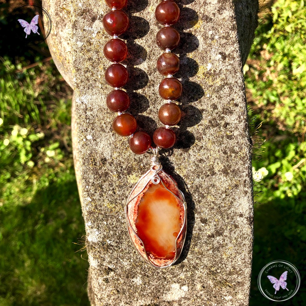 A pendant that has an agate slice and beads is hanging in the stone