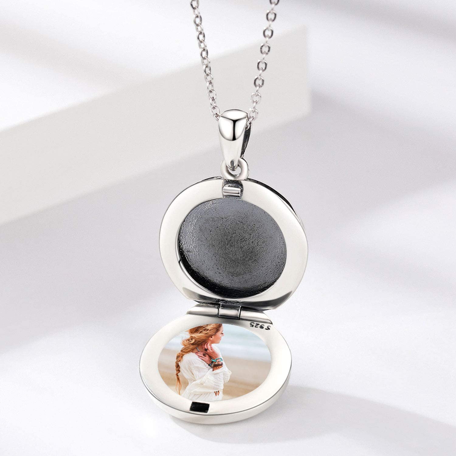 Silver locket necklace with a photo of a woman wearing a white dress
