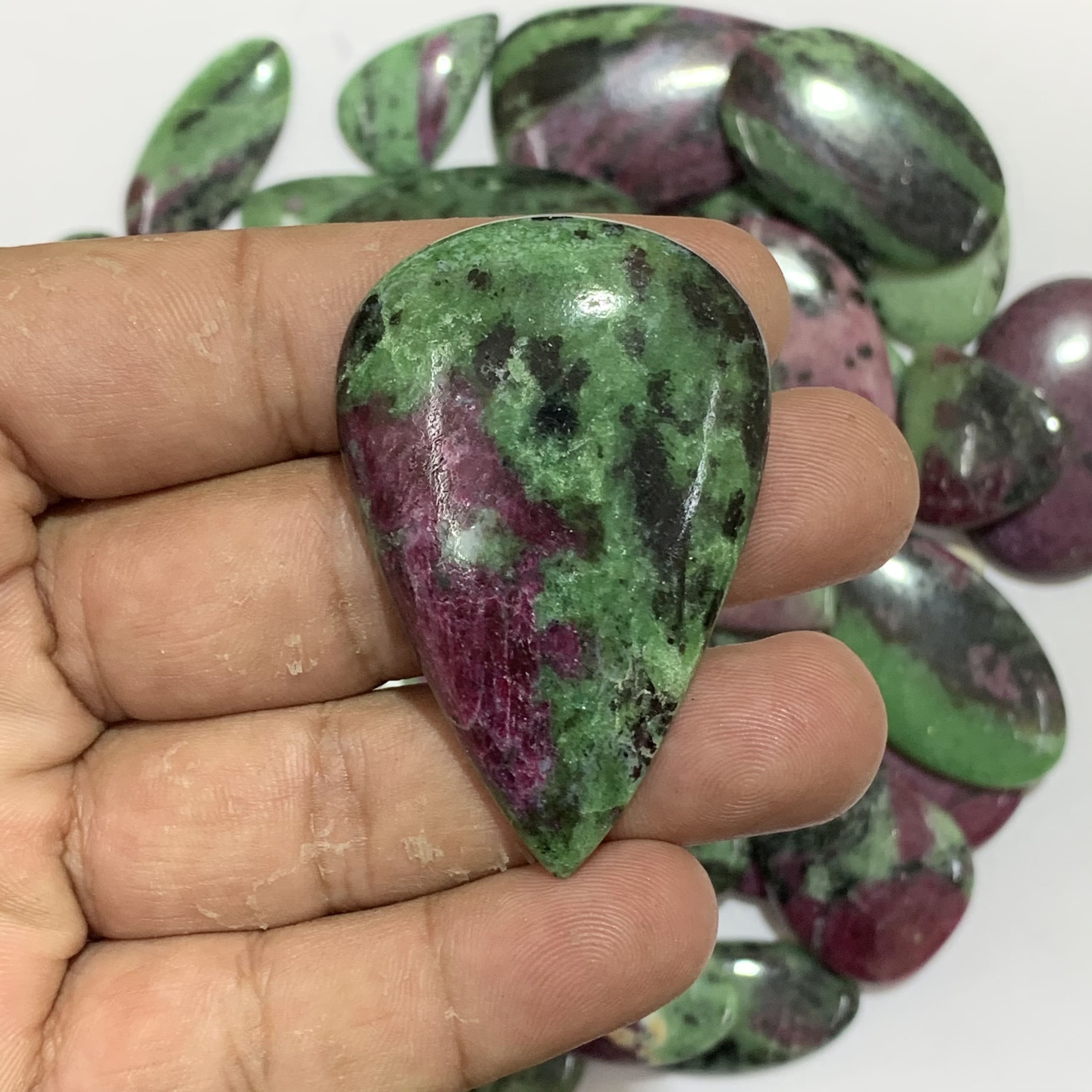 A woman's hand holding a piece of zoisite