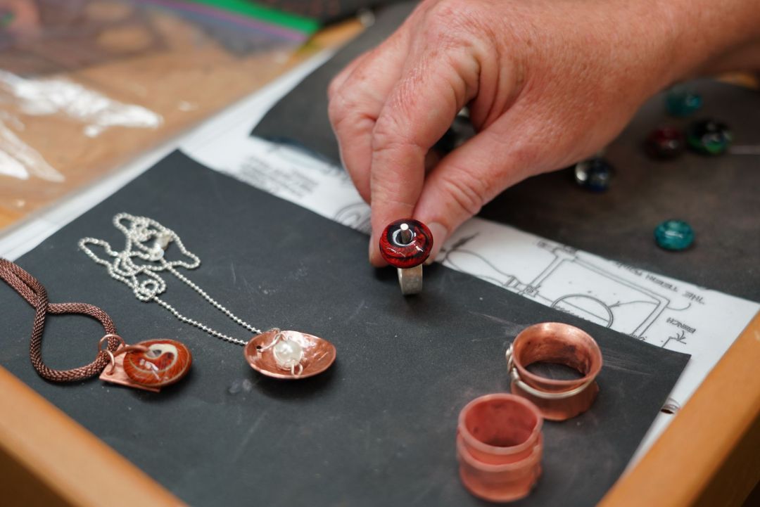 An individual's hand creating and customizing an antique ring
