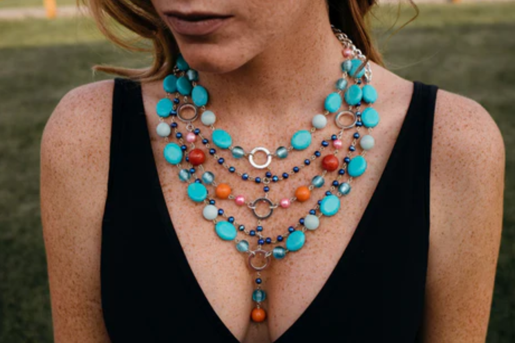 A woman wearing brightly colored beaded statement necklaces