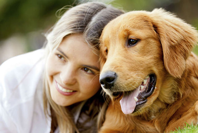 A female pet owner with her golden retriever