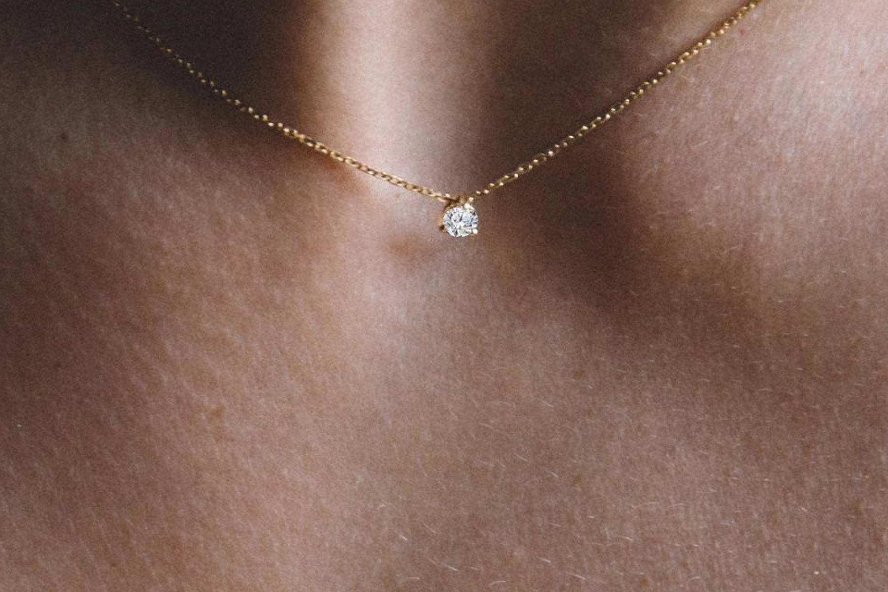 A black woman is dressed in a diamond pendant necklace