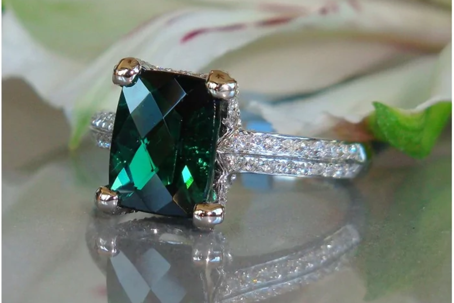 A tourmaline ring resting on a glass table