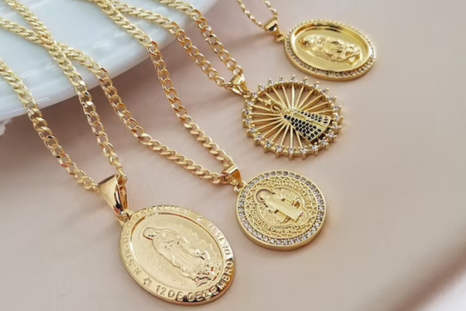 Four distinct varieties of gold pendant necklaces