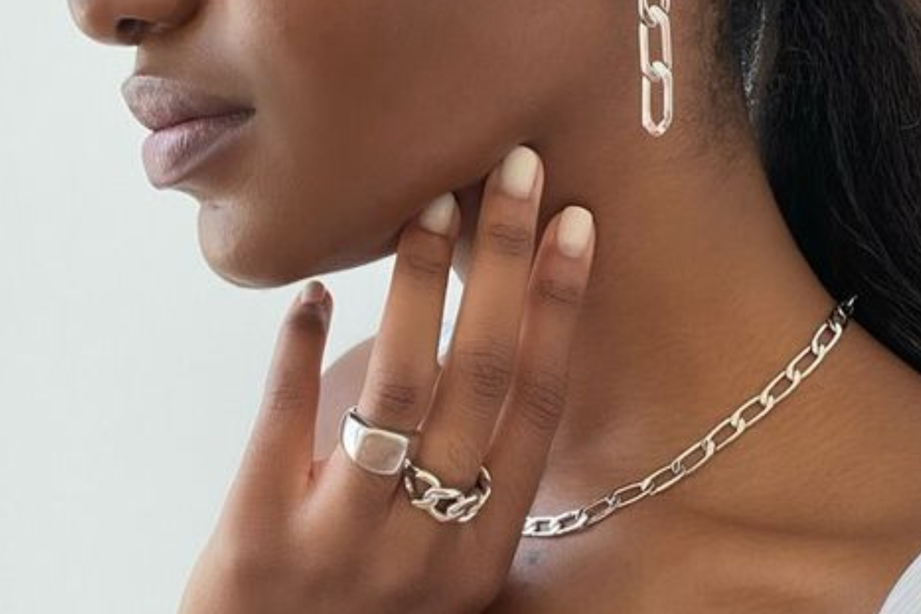 A stunning black woman adorned in silver chain jewelry