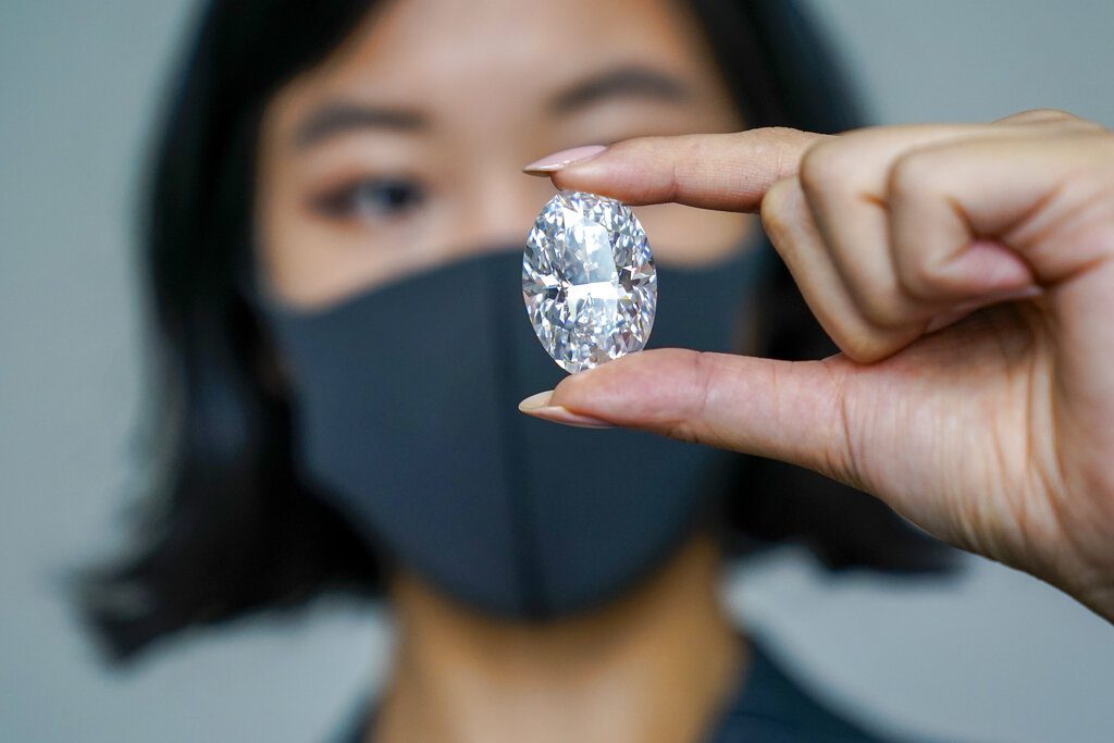 A blurry image of a woman holding a piece of a real diamond