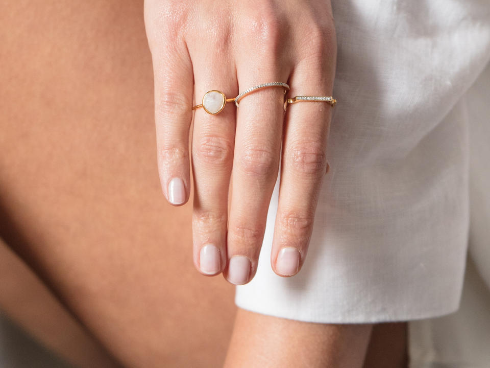 Three minimalist rings on a woman's fingers