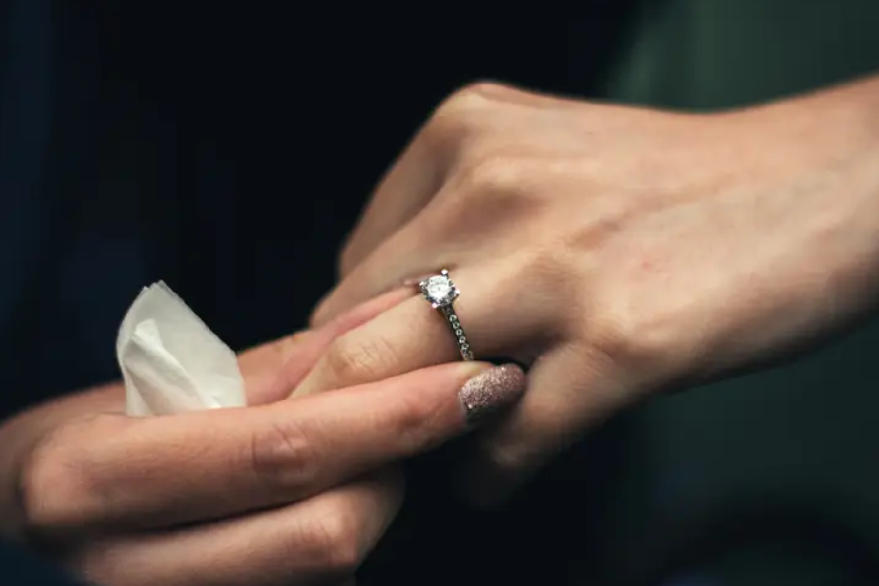 A woman is about to take off her ring finger's fake antique ring