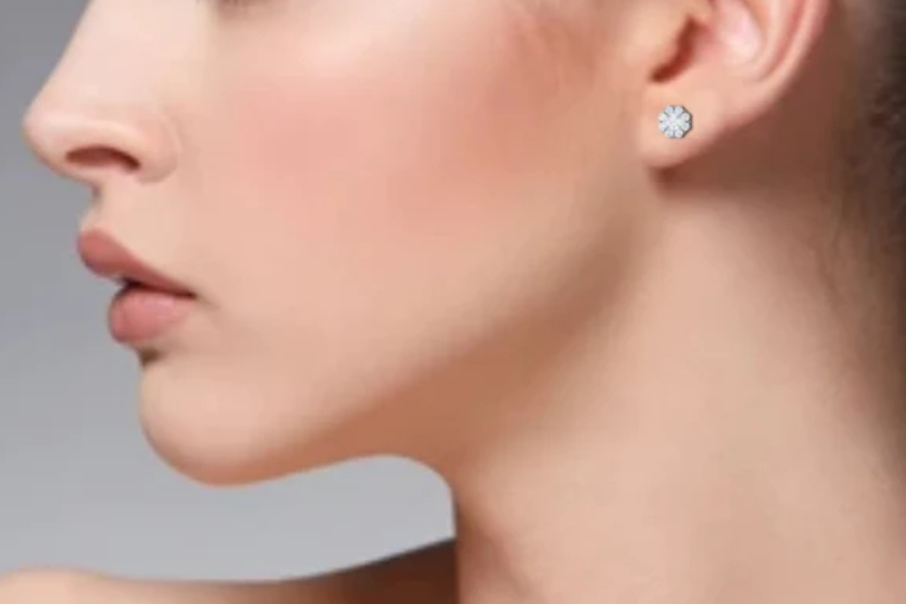 A side view of a woman with platinum earrings