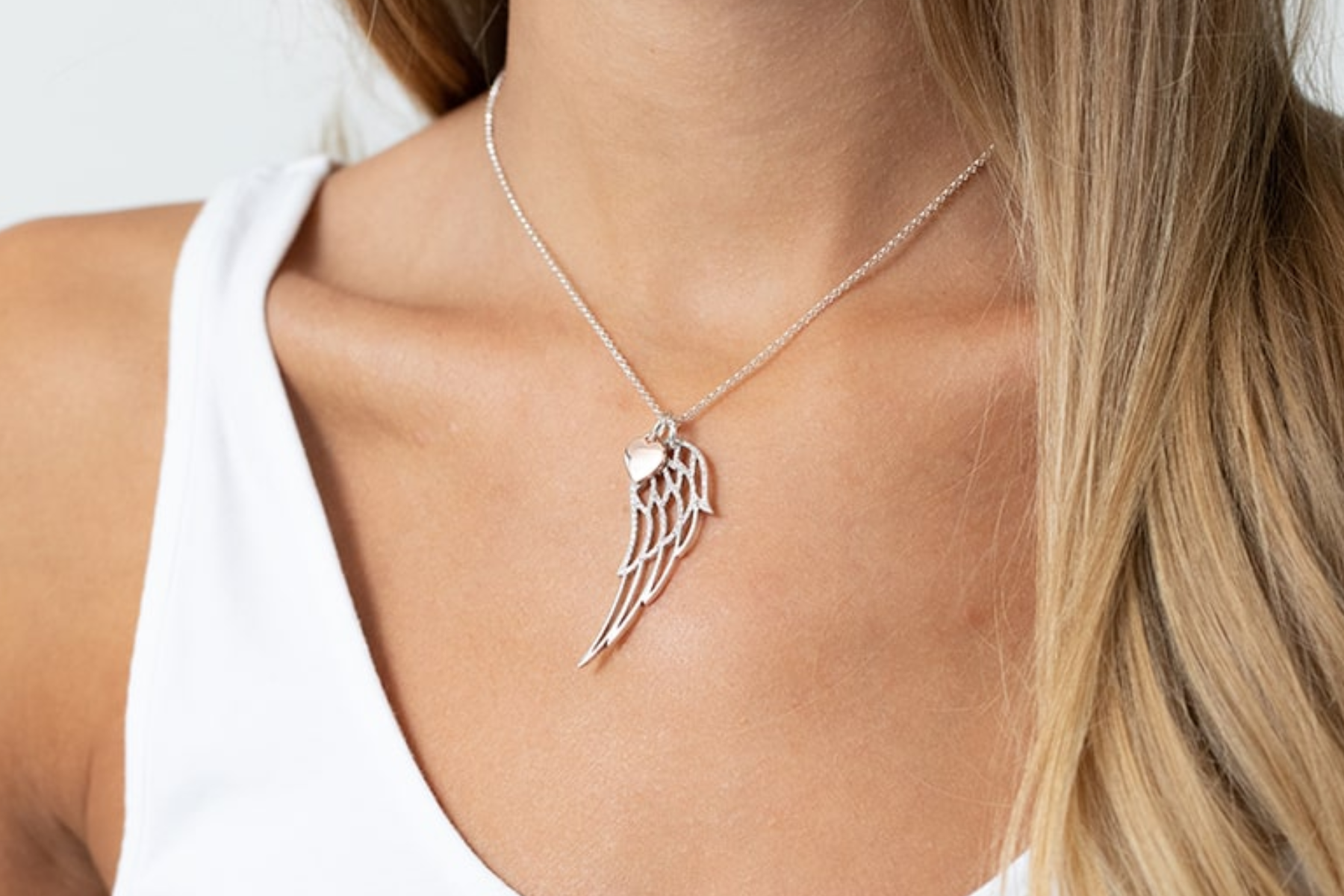 A lady wearing an angel wing pendant