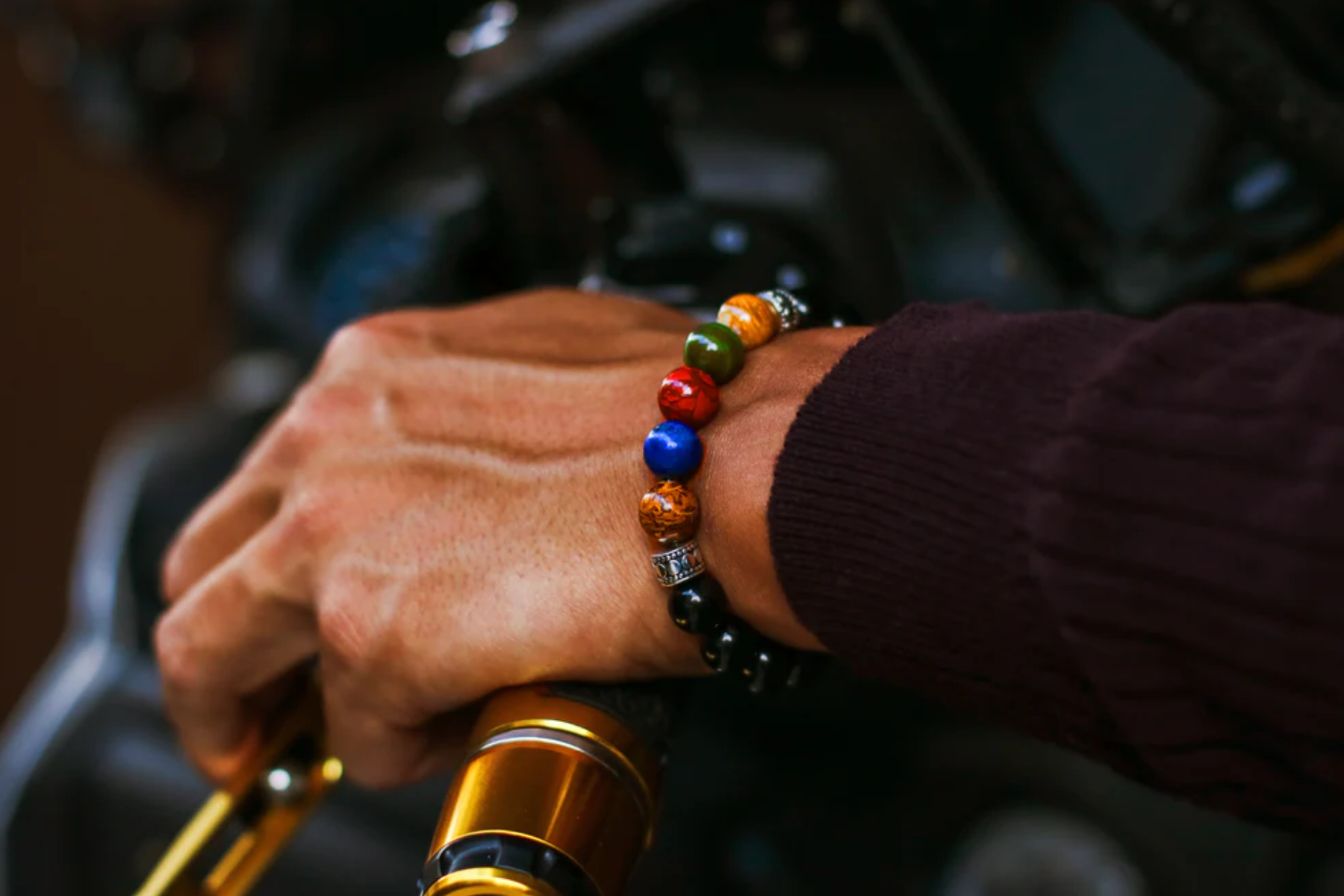 A man's hand wearing a colorful bracelet