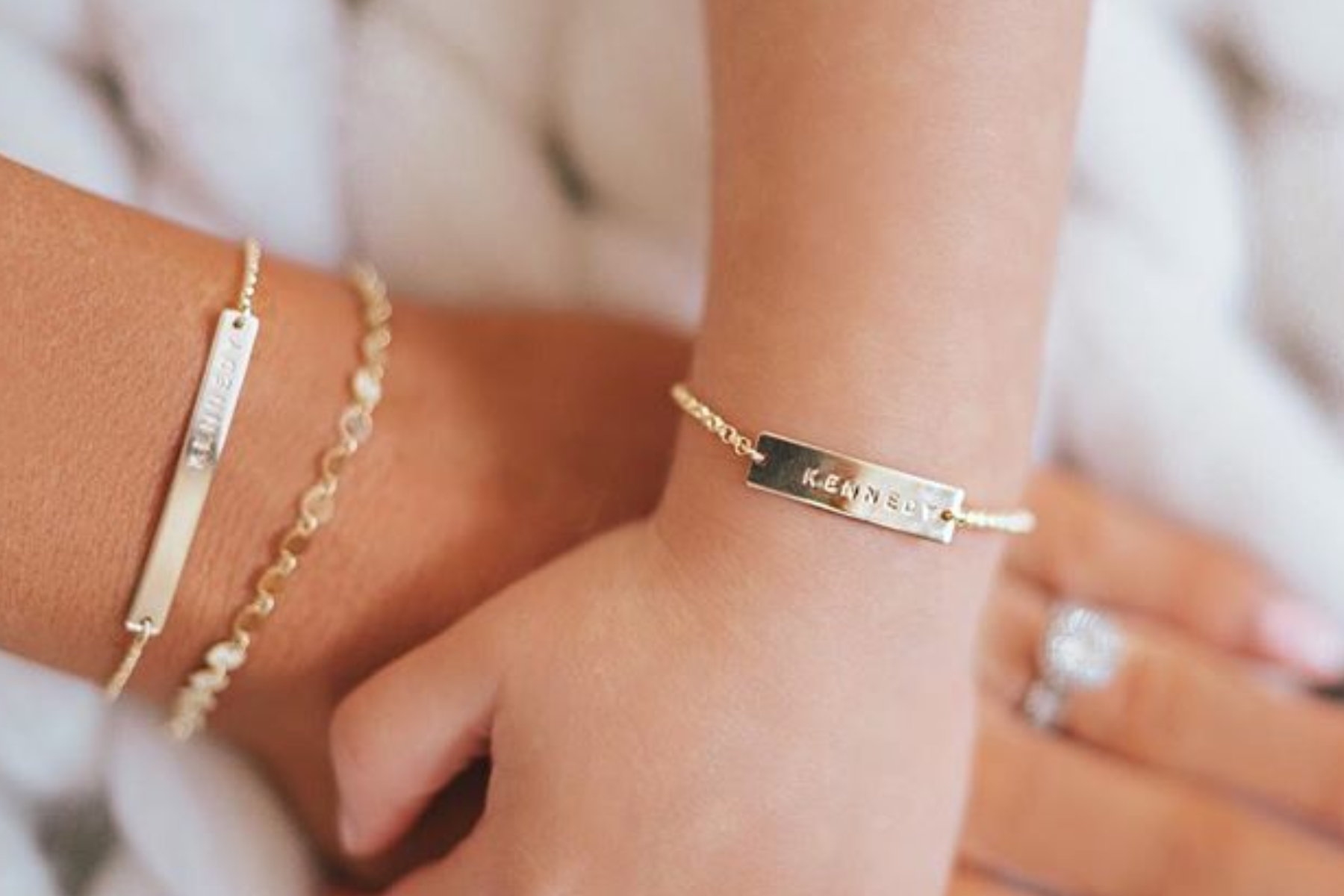 A mother's and a daughter's hands wearing the same bracelet