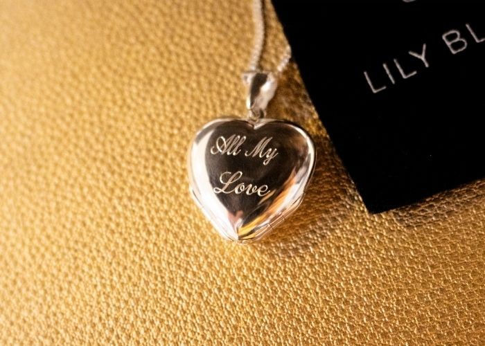 A heart-shaped platinum pendant with the words "All My Love" engraved on it