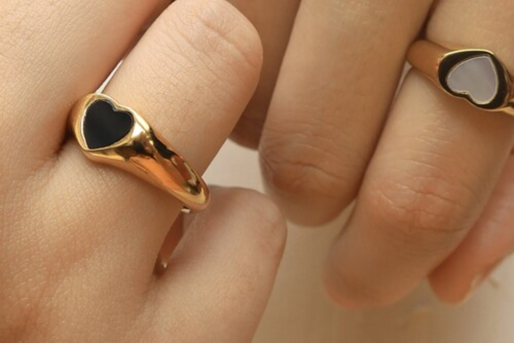 Two people's hands with heart-shaped rings