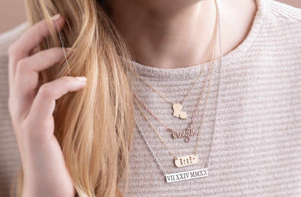 A woman wearing four personalized engraved necklaces