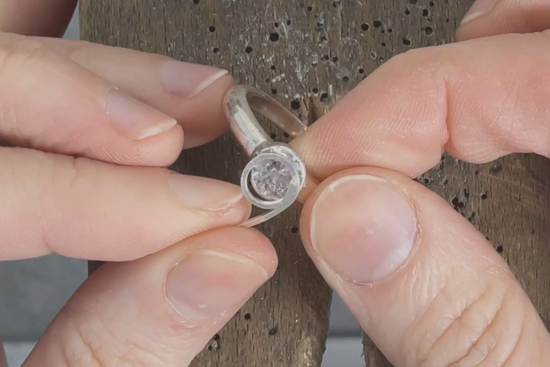 A person's hand holding the stone on a platinum ring