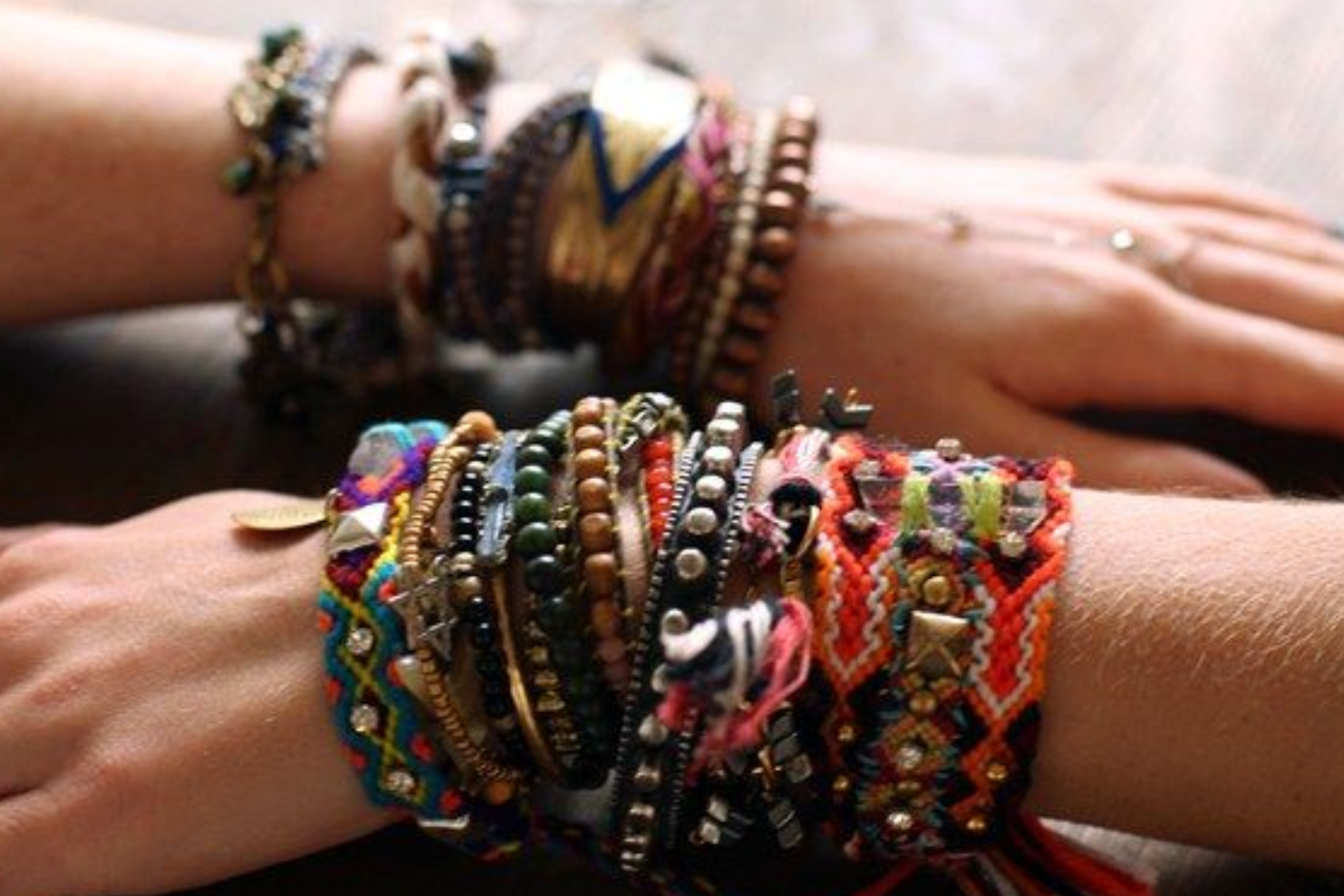 A hand of two people wearing boho bracelet jewelry