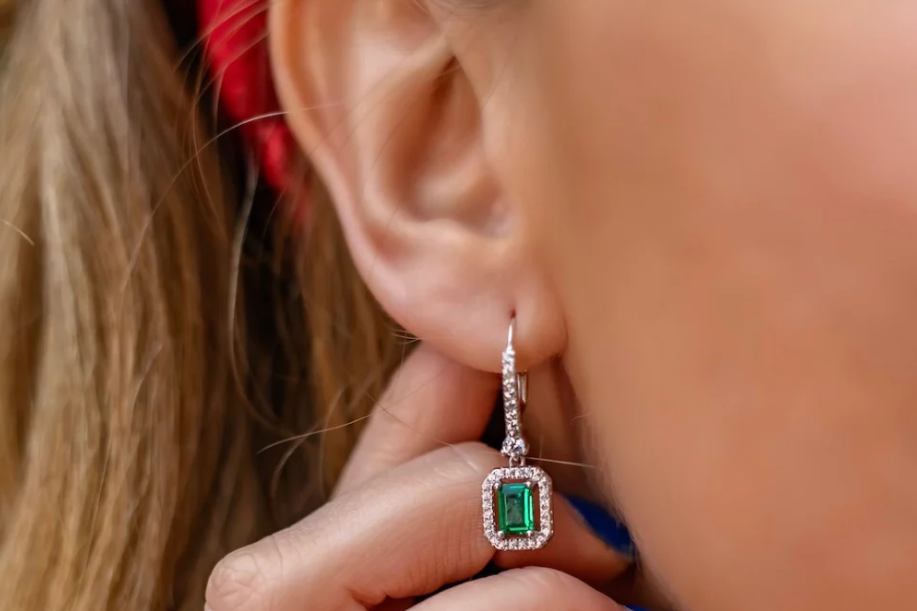 A woman with emerald drop earrings