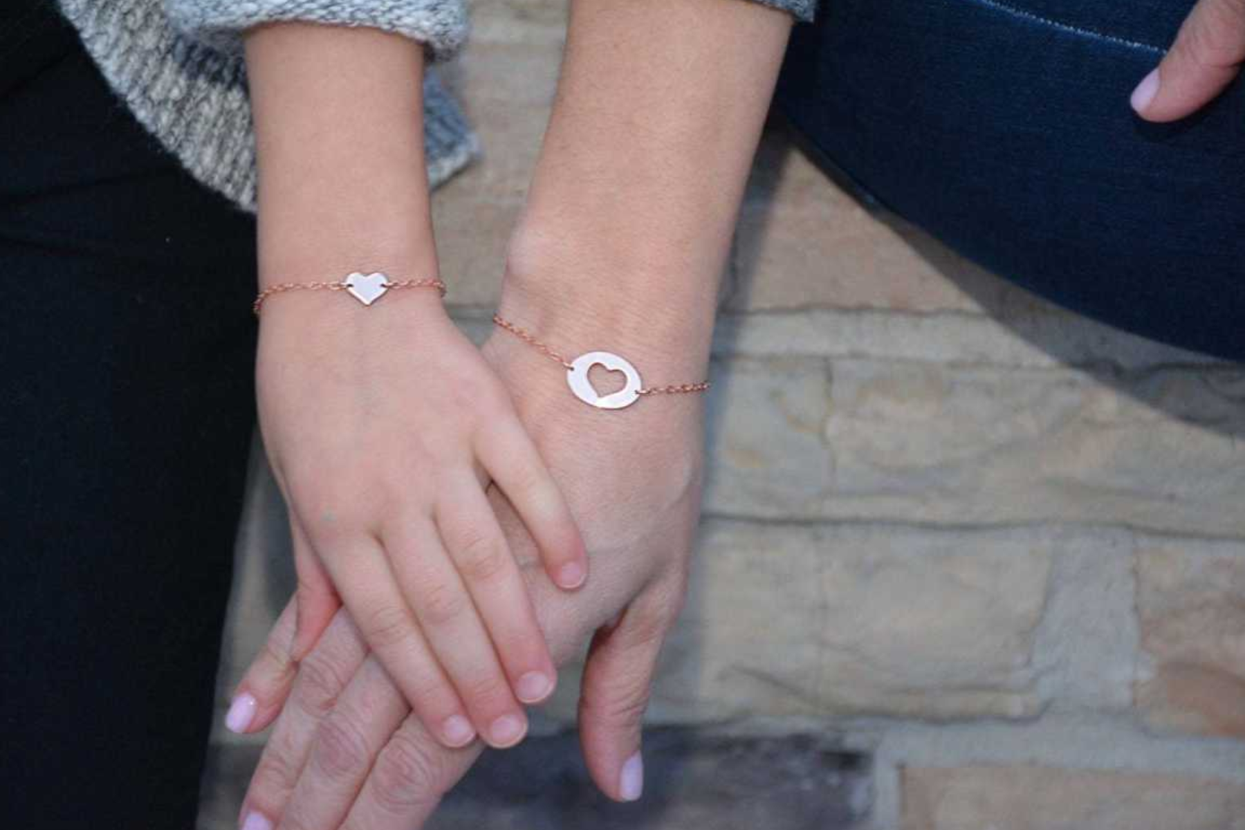 A mother and daughter wearing two equal heart bracelets