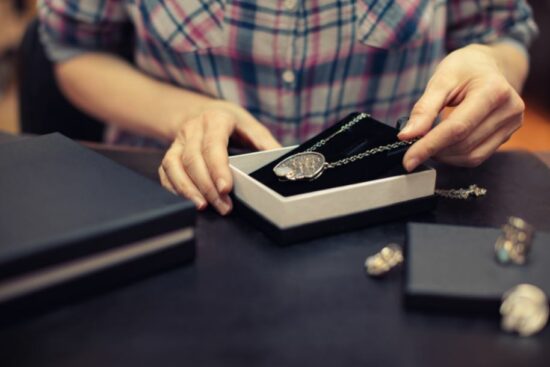 A woman secures a piece of jewelry by placing it in a box
