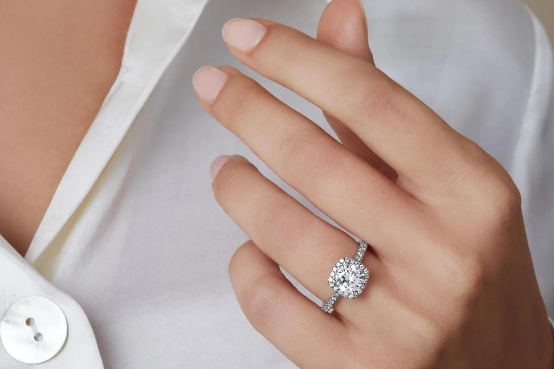 A white woman wearing a round-cut diamond engagement ring
